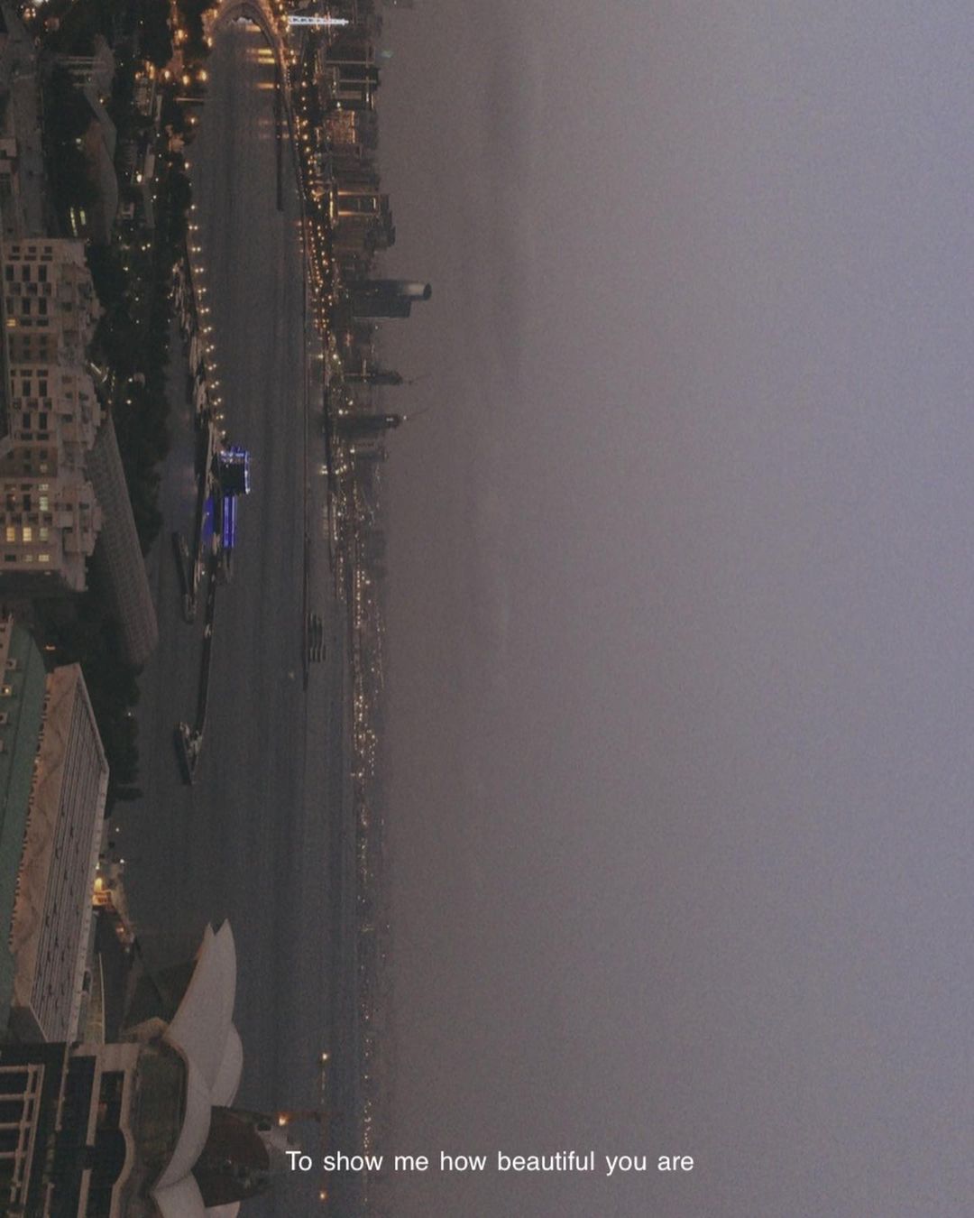 A city waterfront at dusk, turned on its side, fading into mist